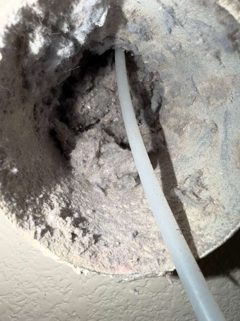 Compacted desert dust clogging air duct wall opening